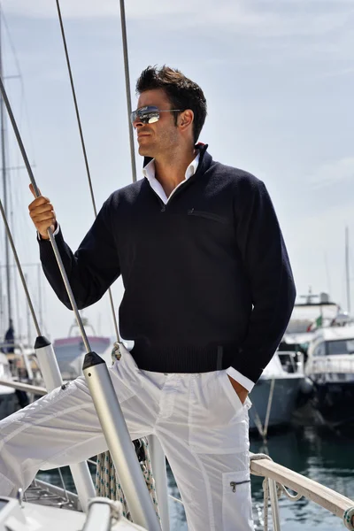 Italy, Tuscany, young model dressed casual on a sailing boat Royalty Free Stock Images