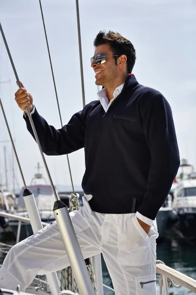Italy, Tuscany, young model dressed casual on a sailing boat Stock Image
