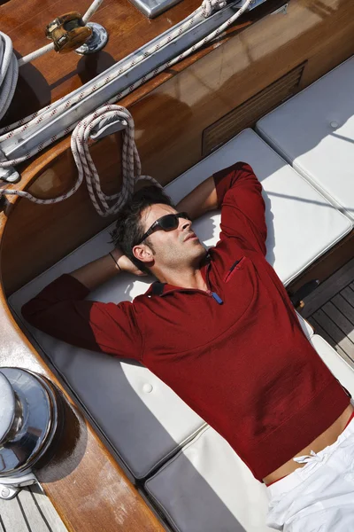 Italy, Tuscany, young sailor is resting on a wooden sailing boat — Stock Photo, Image