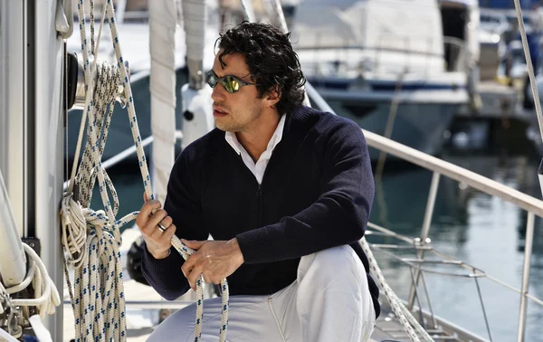 Italy, Tuscany, young sailor dressed casual on a sailing boat Royalty Free Stock Photos