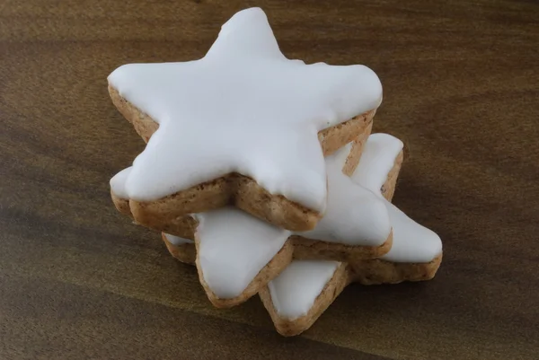 Three cinnamon star cookies on a wooden board — Stock Photo, Image