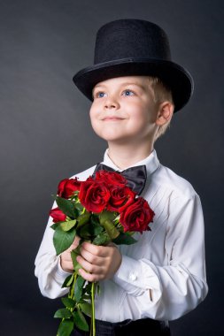 Handsome boy wearing classic suit with flowers in hands clipart