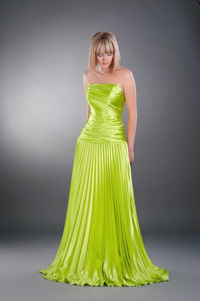 Tarafsız studio zemin üzerine yeşil elbisesi giyen genç ve güzel kadın — Stok fotoğraf