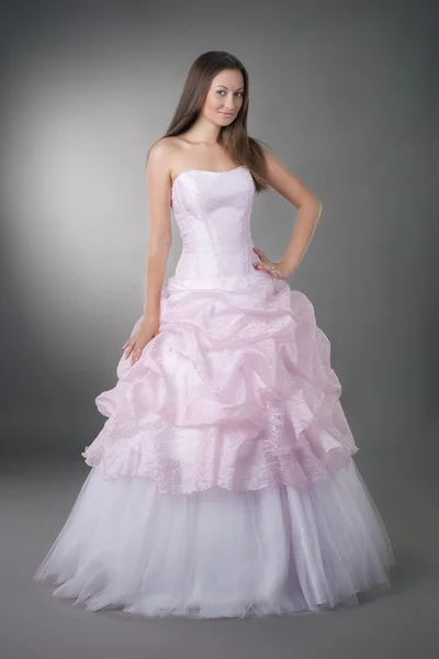 Panna młoda na sobie suknię ślubną na neutralnym tle studio — Zdjęcie stockowe
