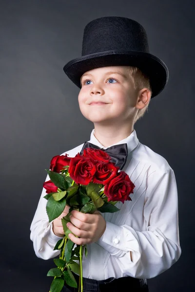 Красивий хлопчик в класичному костюмі з квітами в руках — стокове фото