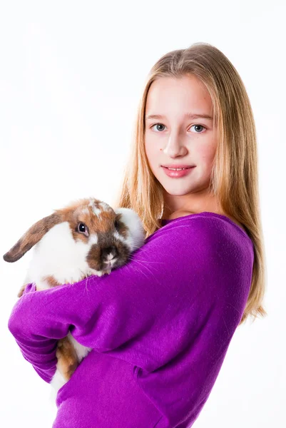 Привлекательная молодая девушка держит кролика изолированным на белом — стоковое фото