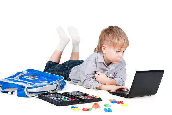 Weinig schooljongen leren met laptop geïsoleerd op witte achtergrond — Stockfoto