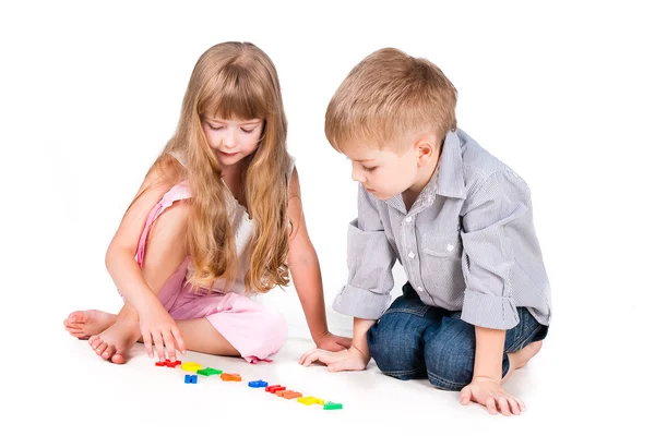 Two playing kids with alphabet isolated on white background — Stock Photo, Image