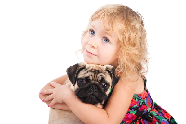 Retrato aislado de niña bonita abrazando perro pug sobre fondo blanco —  Fotos de Stock