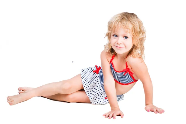 Мила усміхнена маленька дівчинка лежить ізольовано на білому тлі — стокове фото