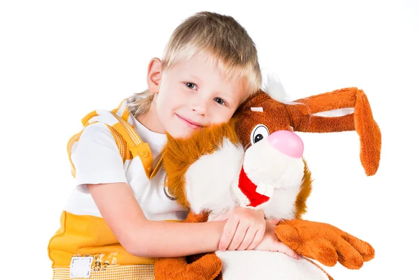 Menino com um coelho de brinquedo isolado no fundo branco — Fotografia de Stock