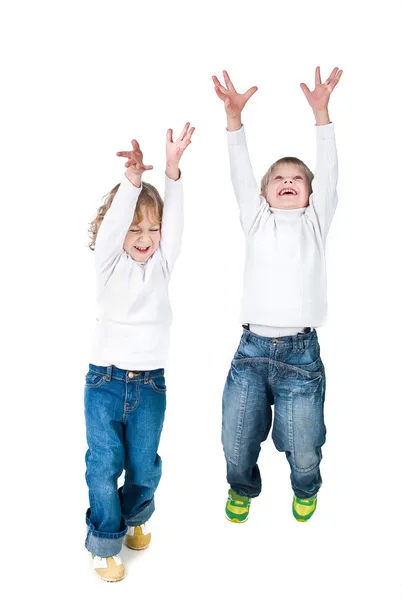Двоє схвильованих дітей стрибають вгору ізольовано на білому тлі — стокове фото