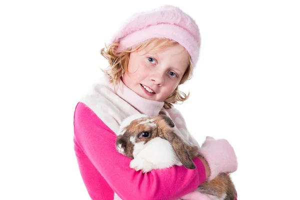 Cute teen girl wearing winter apparel carrying rabbit isolated on white — Stock Photo, Image