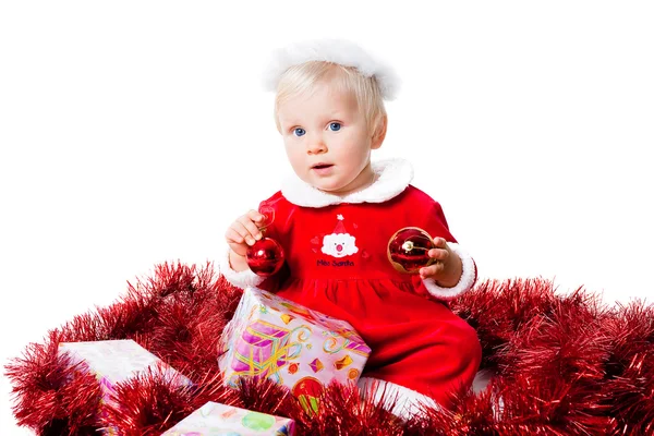 Bebé niña usando traje de Santa sentado con juguetes aislados fondo blanco — Foto de Stock