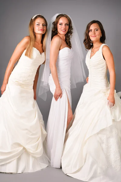 Три красивые невесты позируют на нейтральном фоне студии — стоковое фото