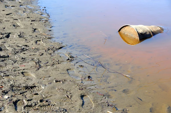 Roestige vat vervuilt rivier — Stockfoto