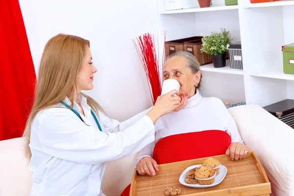 Pielęgniarka pomoc starsza kobieta — Zdjęcie stockowe