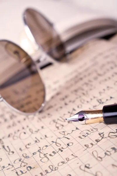 Золотая ручка с письмом от руки . — стоковое фото