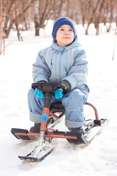 Happy little boy for a walk in a winter park, sledging at sleig — Stock Photo, Image
