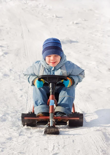 Szczęśliwy chłopczyk na spacer w winter park, jazda na sankach w sleig — Zdjęcie stockowe