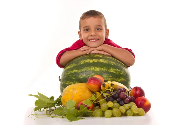 Healthy boy and fresh banana melon watermelon grapes peach — Stock Photo, Image