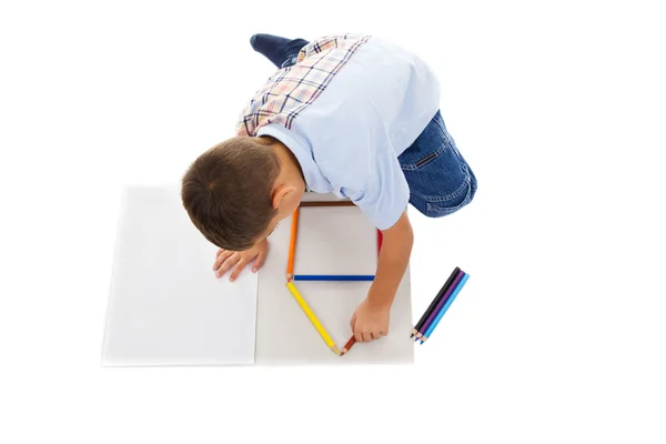 Мальчик строит дом на белой бумаге с карандашом — стоковое фото