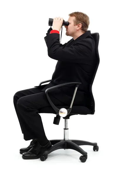Uomo seduto sulla sedia e alla ricerca con binocolo — Foto Stock