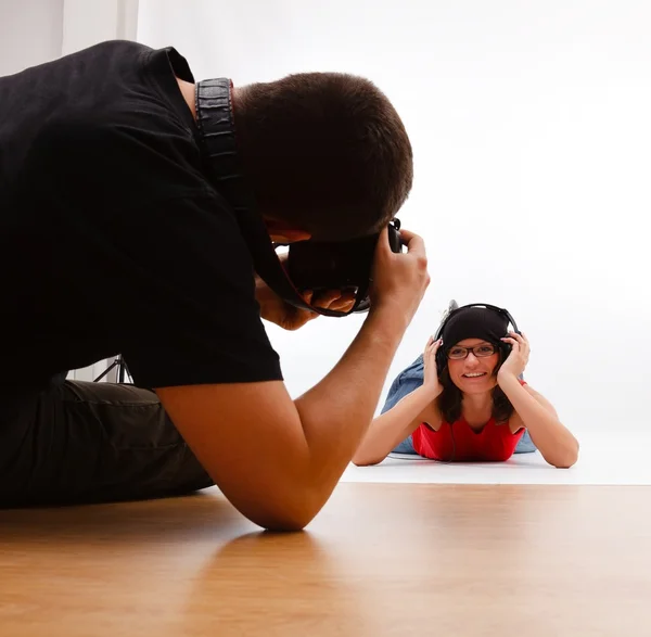 Photographer taking picture of woman laying on floor — Stock Photo, Image
