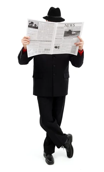 Человек в черном покрывает себя газетой — стоковое фото