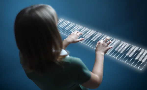 Flicka som leker på virtual piano keyboard — Stockfoto
