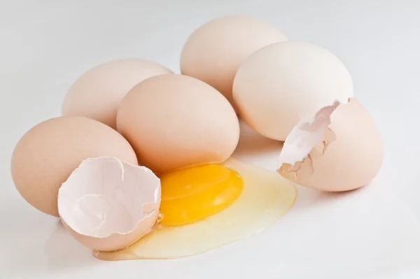 Розбите яйце на білому тлі — стокове фото