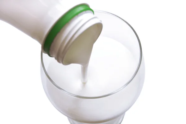 The white yogurt gets into from bottle in glass — Stock Photo, Image