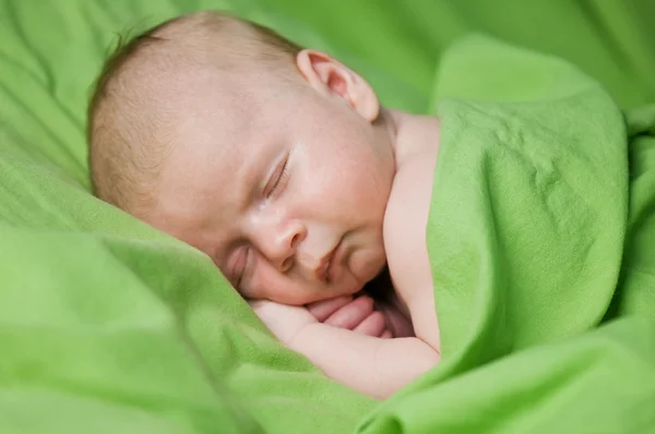 Menino recém-nascido dormindo sob lençol verde — Fotografia de Stock