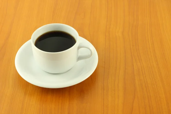 Beyaz ahşap masa üzerinde koyu bir kahve fincan. — Stok fotoğraf