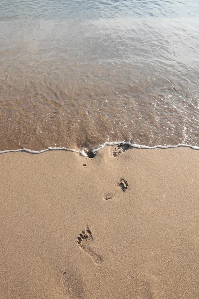 Passi del piede cancellati dall'onda . — Foto Stock