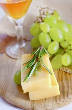 Cheese on wooden board with berries and rosemary clipart