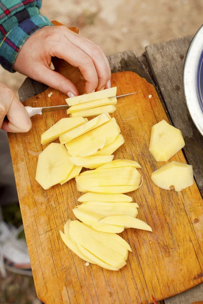 stock image Female hands cut potato