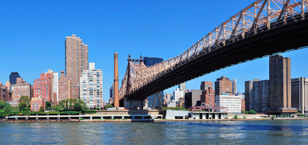 Queensborough Bridge in Midtown Manhattan with New York City skyline panorama over East River as the famous landmarks viewed from Brooklyn.