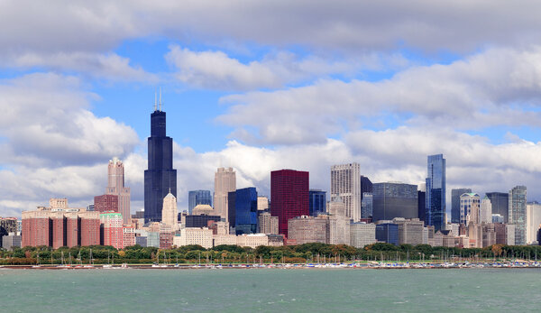 Chicago skyline panorama with skyscrapers over Lake Michigan with cloudy blue sky.
