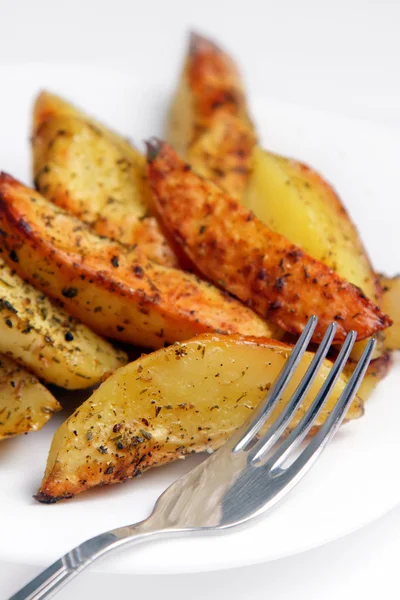 Stekt potatis på en vit platta med en gaffel. — Stockfoto