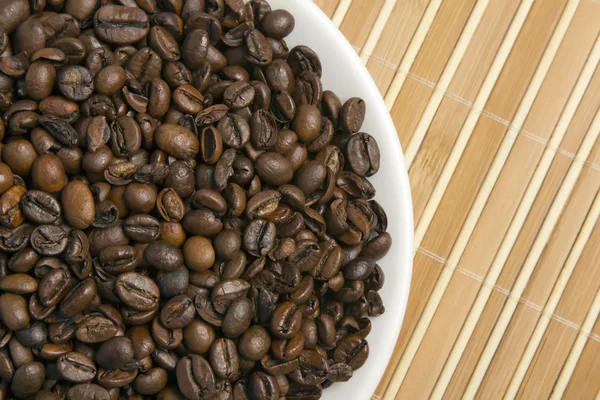 Kaffebönor på ett tefat — Stockfoto