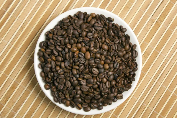 Кофейные зерна на тарелке — стоковое фото