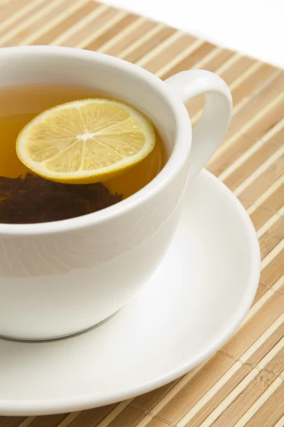Czarna herbata z cytryną w filiżance biały — Zdjęcie stockowe