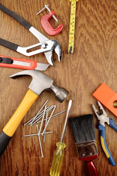 Assorted work tools on wooden panel — Stock Photo, Image