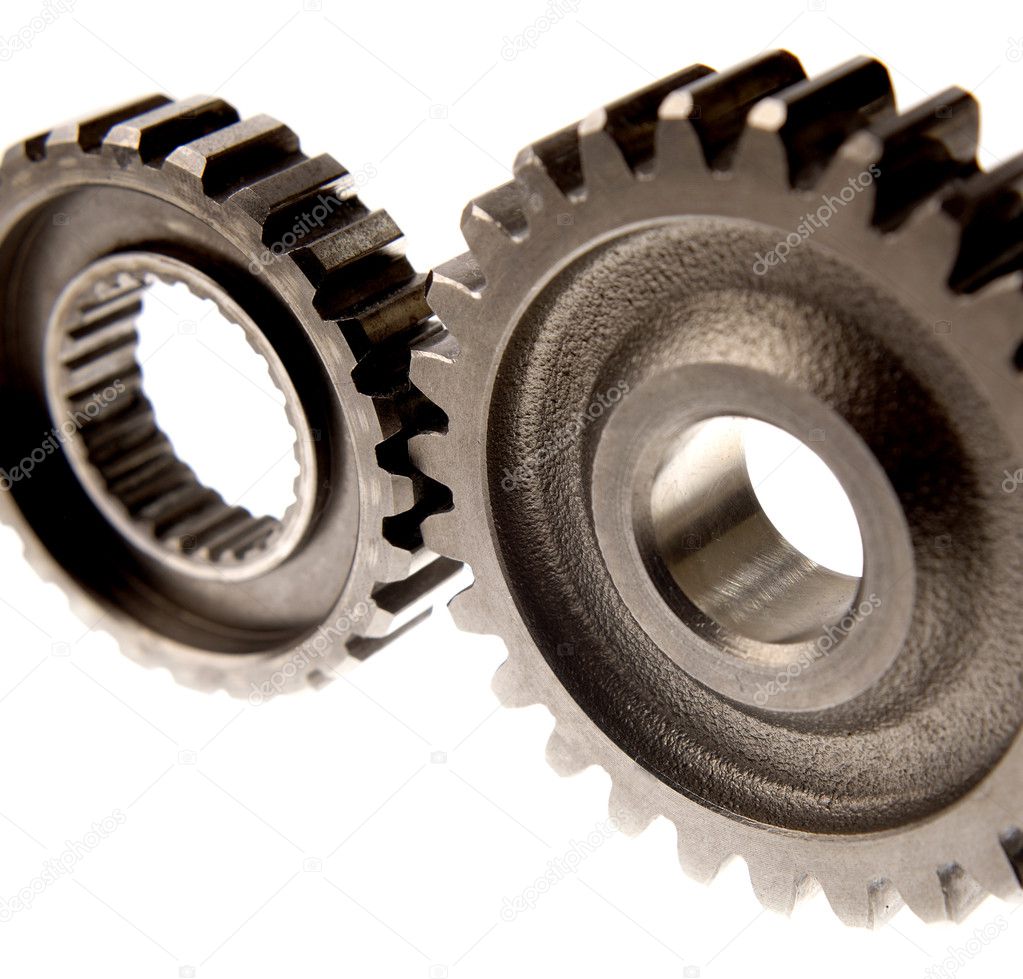 Closeup of two steel gears on white