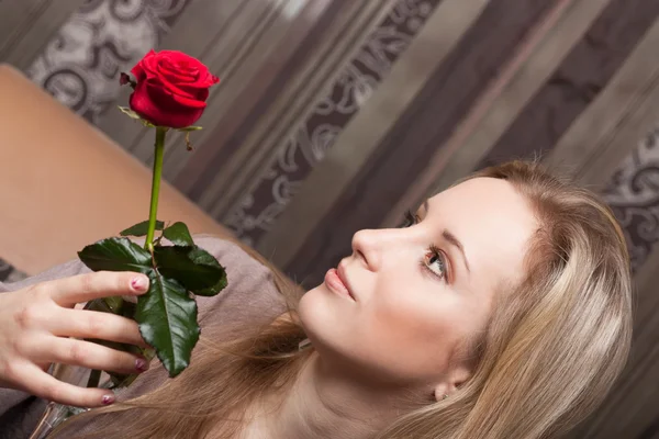 Femme blonde sensuelle tenant une rose rouge — Photo