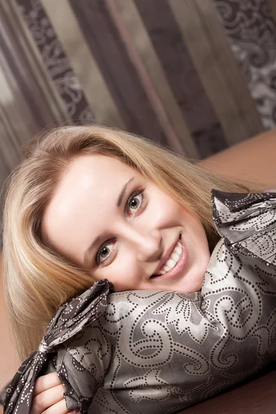 Leende ung blond tjej med en kudde — Stockfoto