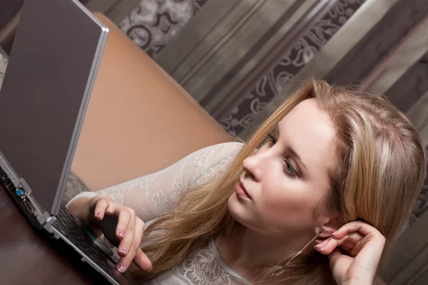 年轻漂亮的金发姑娘用一台笔记本电脑 — 图库照片
