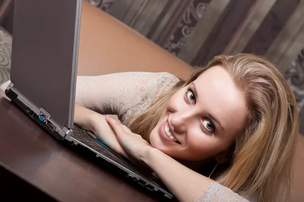 Sonriente chica rubia elegante con un ordenador portátil — Foto de Stock