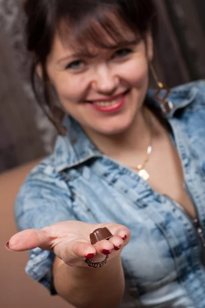 Vacker ung flicka som håller en choklad godis — Stockfoto